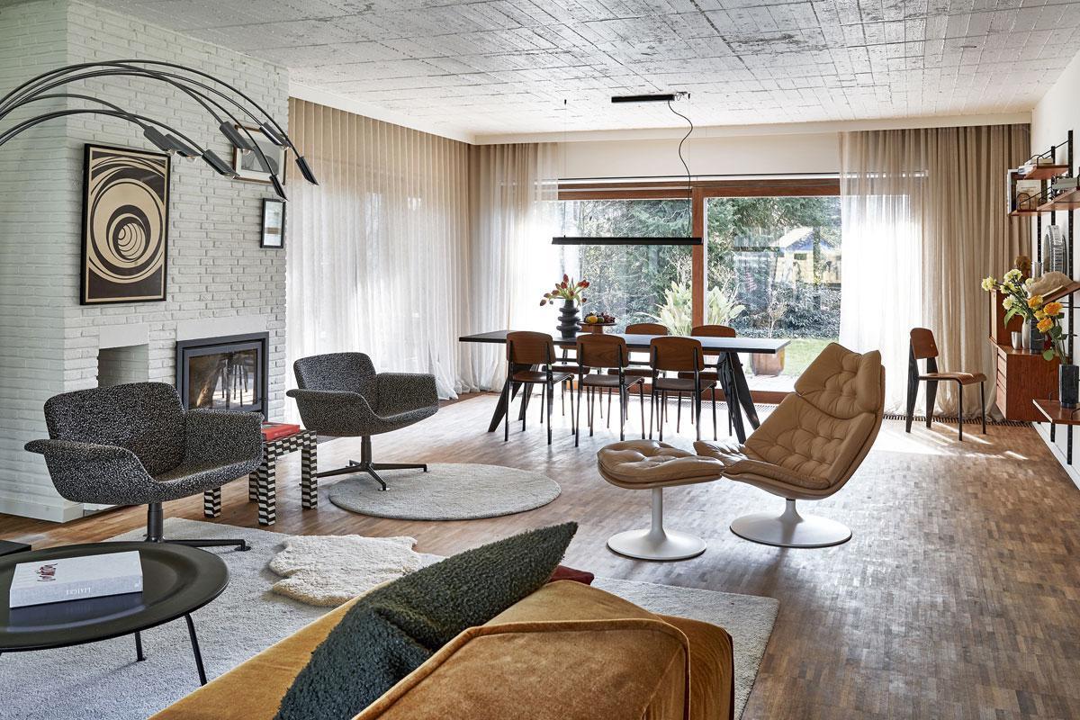 De bewoners leven tussen vintage en heruitgaven van ontwerpen uit de tijd van hun bungalow. Vooraan een lounge chair van Geoffrey Harcourt voor Artifort, de eetkamer is van Jean Prouvé, in de Vitra-editie.